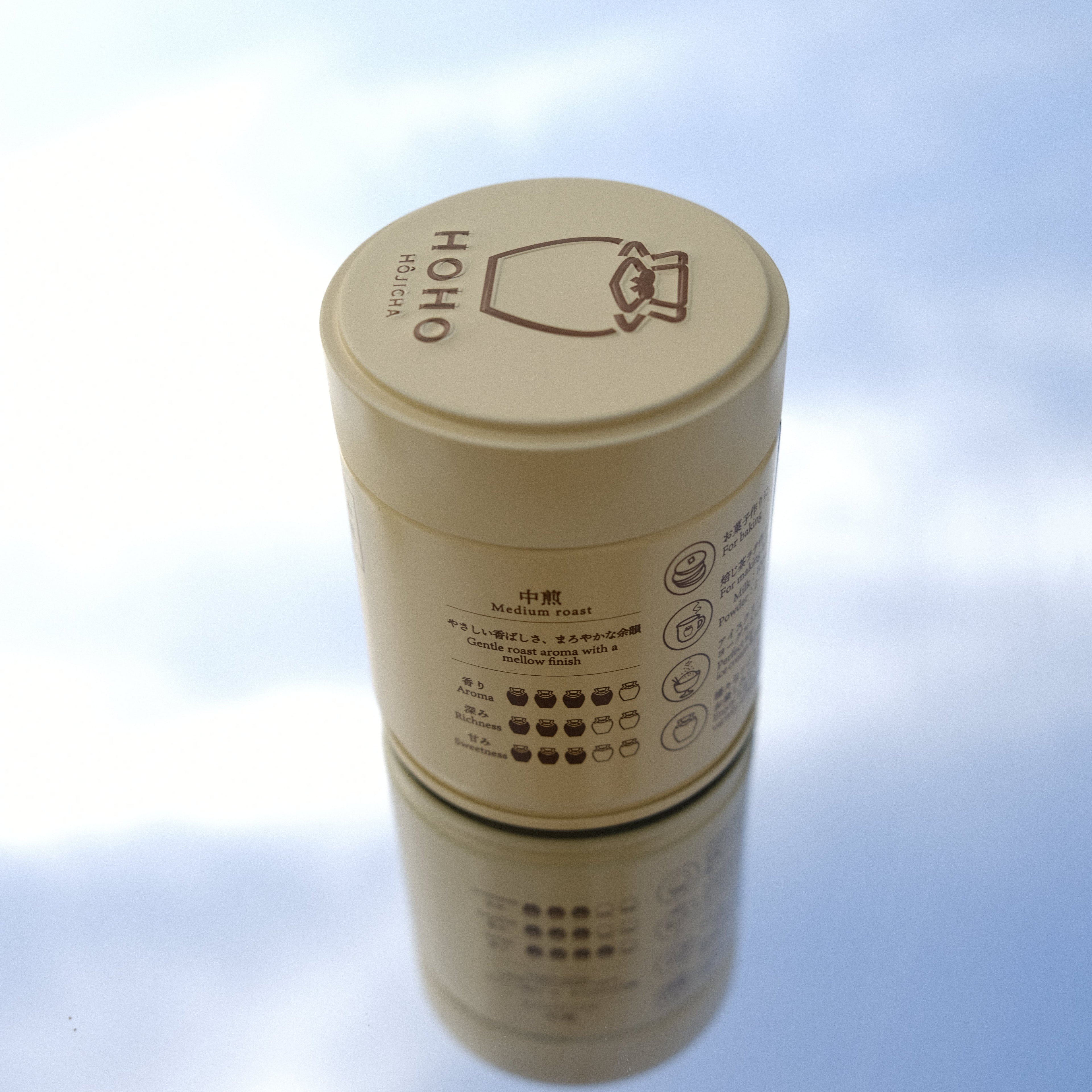 Beige cylindrical container with text and symbols on a blurred background