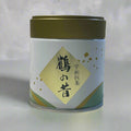 Tea canister with gold lid and green label on a white fabric background